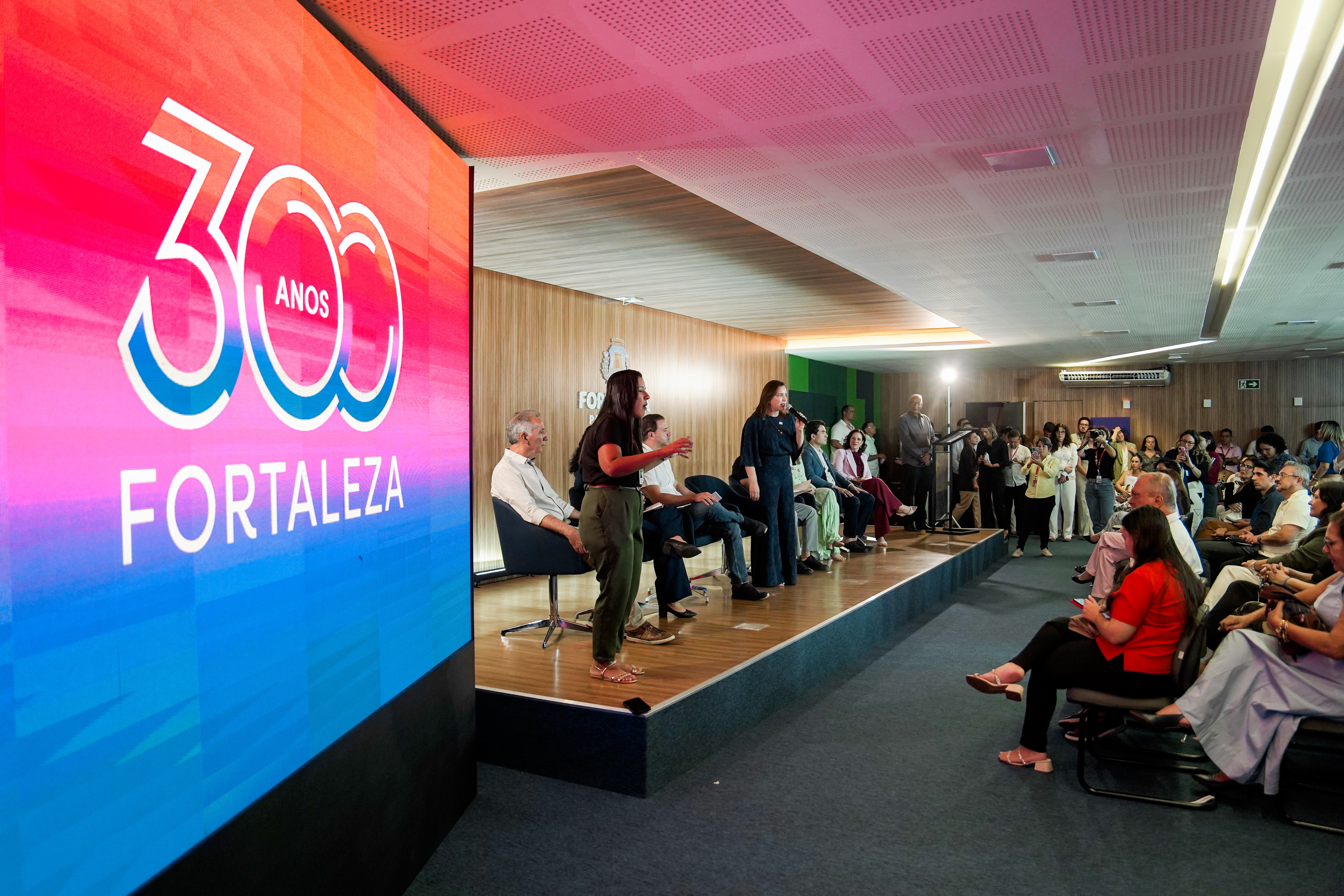 primeira-dama Cristiane Leitão falando no palco do auditório do Paço